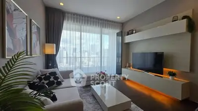 Modern living room with large window and stylish decor in high-rise apartment.
