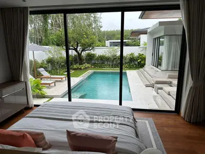 Luxurious bedroom with pool view and lush garden, perfect for relaxation and comfort.