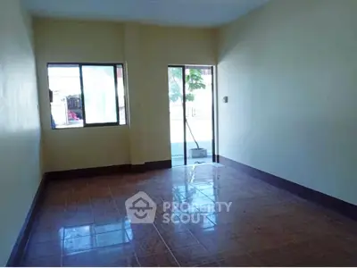 Spacious empty room with tiled floor and large windows, perfect for customization.