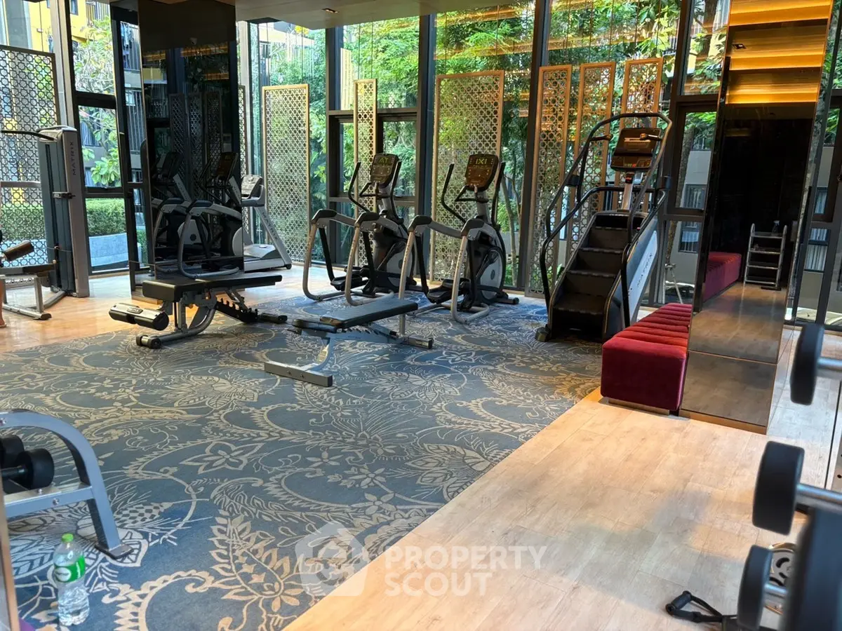 Luxurious gym with modern equipment and elegant decor in upscale residential building.