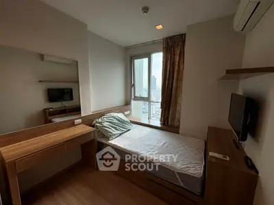 Cozy bedroom with city view, featuring a single bed, wooden furniture, and air conditioning.