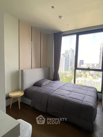Modern bedroom with stunning city view from large window, featuring cozy bed and stylish decor.