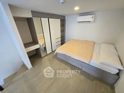 Modern bedroom with mirrored wardrobe and air conditioning unit