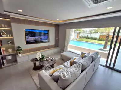 Luxurious living room with pool view, modern decor, and cozy seating area.