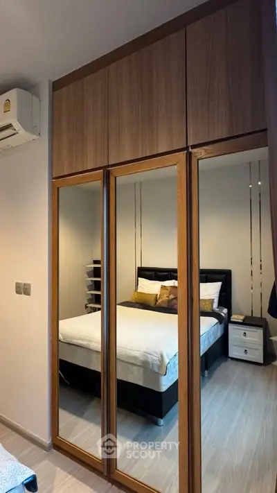 Modern bedroom with mirrored wardrobe and cozy bed in stylish apartment.