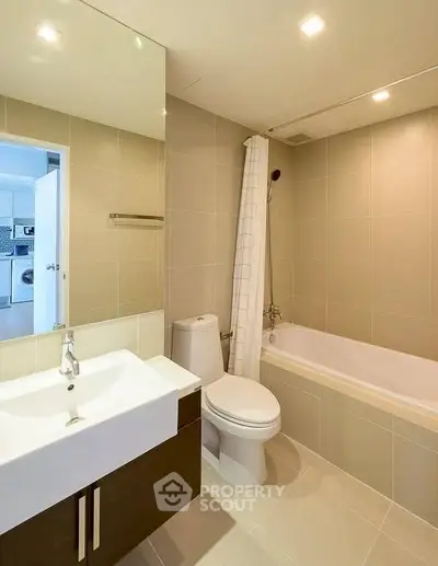 Modern bathroom with sleek fixtures and a bathtub in a contemporary apartment.