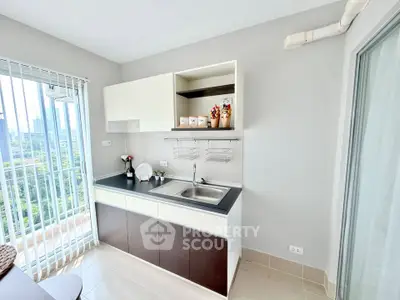 Modern kitchen with sleek cabinetry and city view from balcony, perfect for urban living.