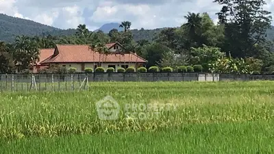 Charming countryside property with lush greenery and scenic mountain backdrop.