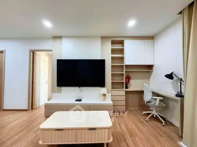 Modern living room with sleek TV setup and stylish workspace