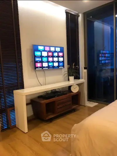 Modern bedroom with sleek TV setup and stylish wooden flooring
