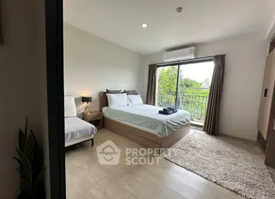 Spacious bedroom with balcony and modern decor, offering serene views and ample natural light.