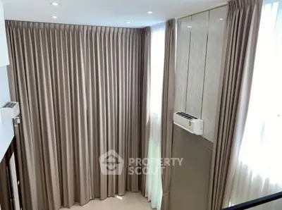 Spacious corner unit with elegant floor-to-ceiling curtains and modern air conditioning.