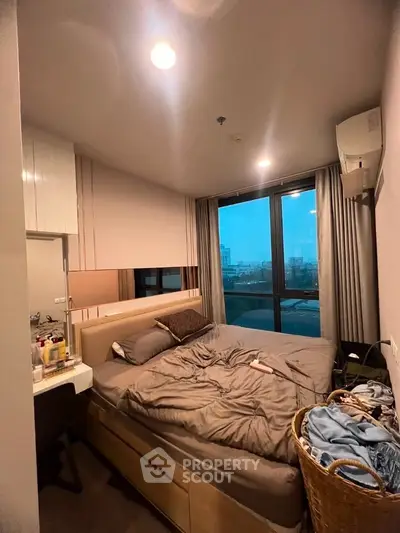 Cozy bedroom with city view, featuring a comfortable bed and modern decor, perfect for urban living.