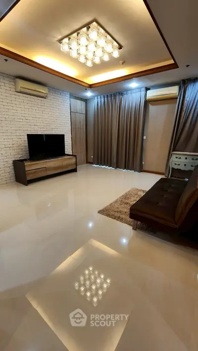 Spacious modern living room with elegant lighting and sleek furnishings.