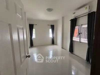 Spacious unfurnished room with large windows and air conditioning, perfect for customization.
