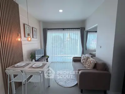 Modern living room with cozy sofa, dining area, and large window offering city view.