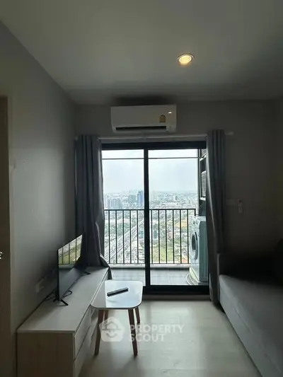 Modern living room with balcony offering stunning city view, featuring sleek furniture and air conditioning.