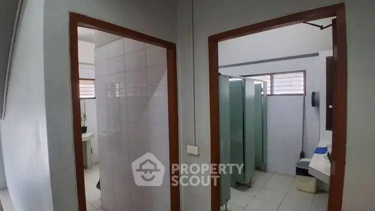 Public restroom with multiple stalls and sinks in a clean, tiled environment.