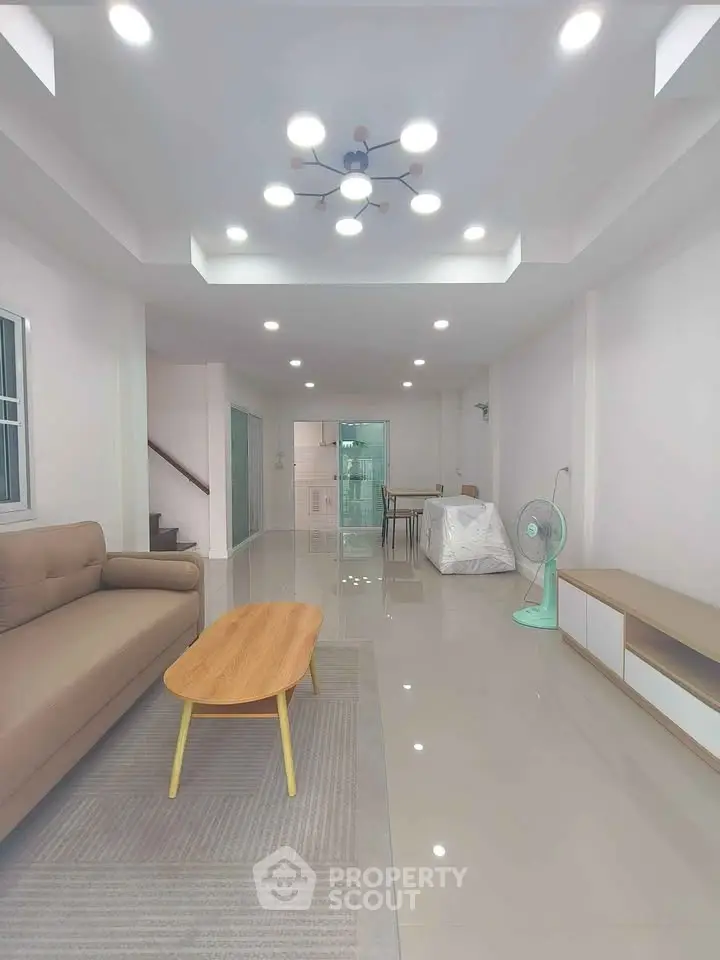 Spacious modern living room with sleek design and ample lighting, perfect for family gatherings.