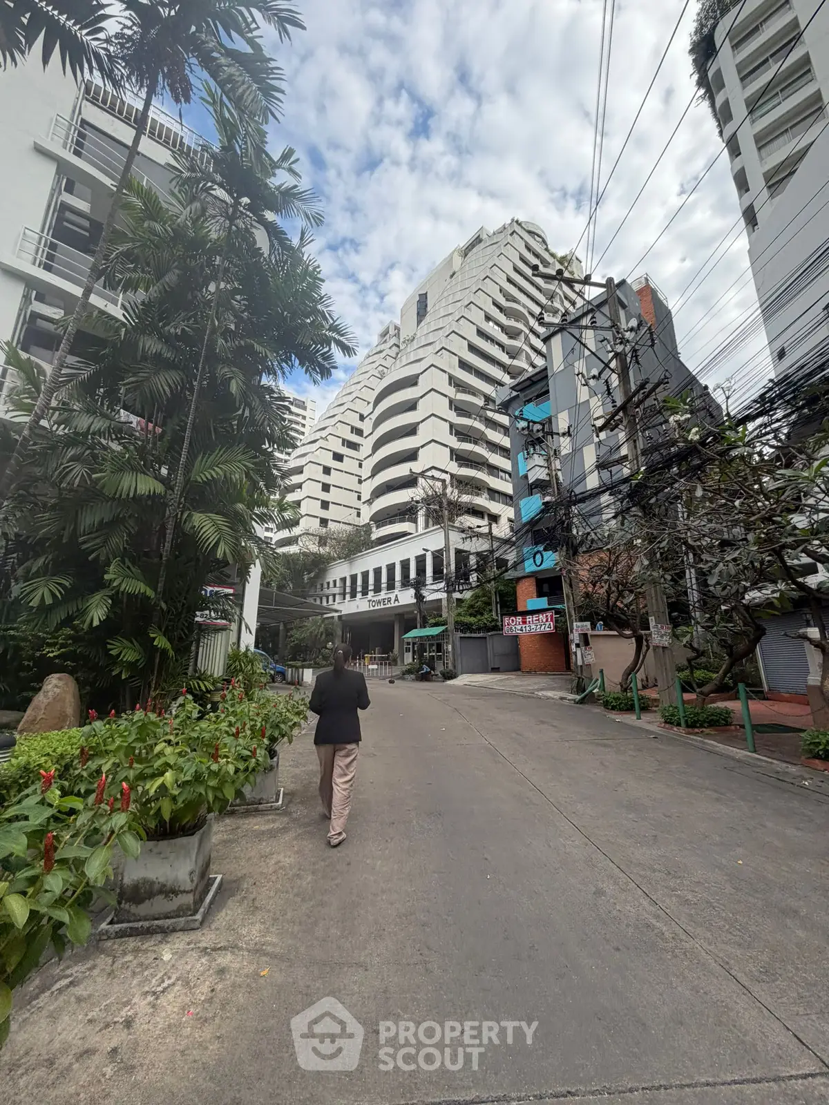 Modern high-rise building with lush greenery and clear sky