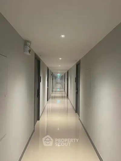 Modern apartment building hallway with sleek design and polished floors.