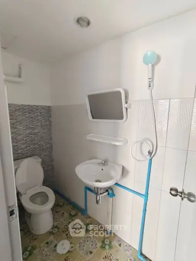 Compact bathroom with modern fixtures and tiled walls, featuring a shower and toilet.