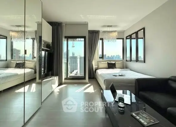 Modern living room with city view, featuring sleek furniture and large windows.