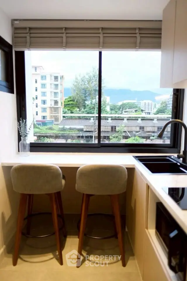 Modern kitchen with a stunning city view, featuring sleek countertops and stylish bar stools.