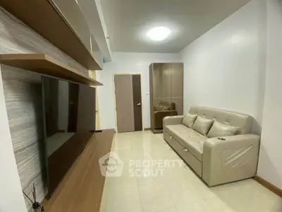 Modern living room with sleek TV setup and comfortable sofa in a cozy apartment.