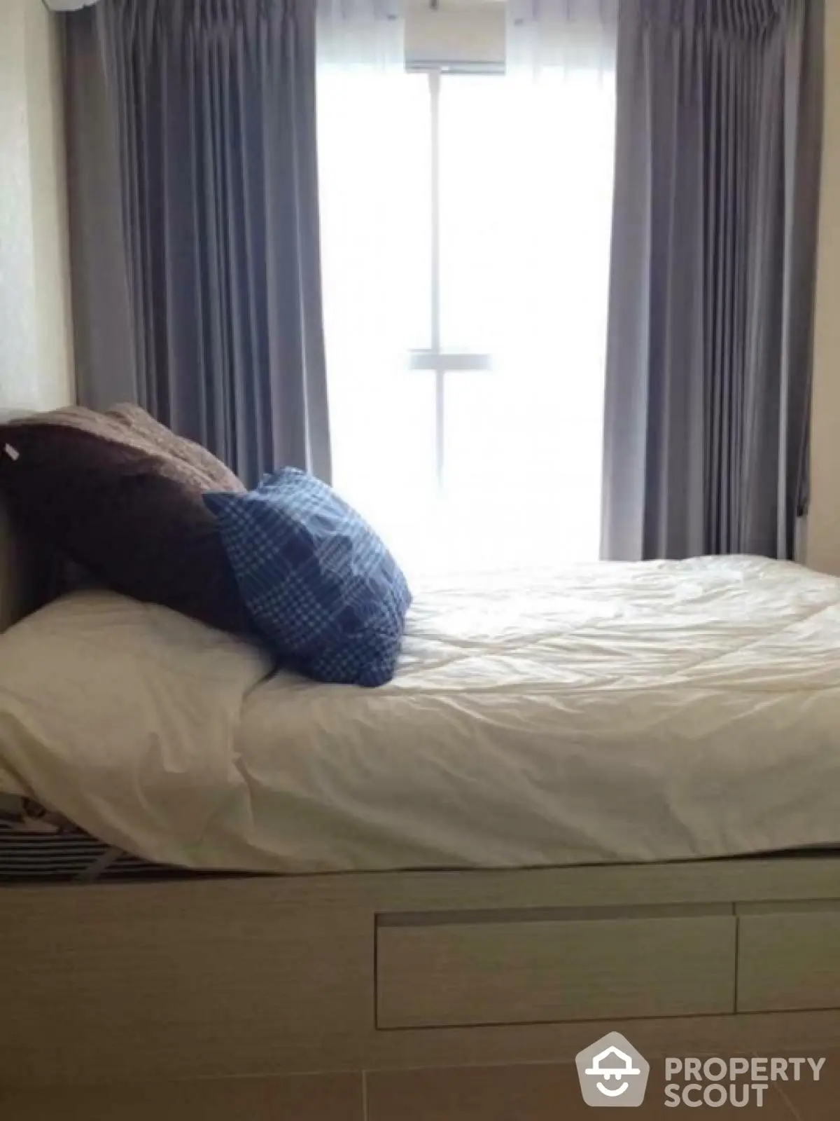 Cozy bedroom with natural light and stylish curtains, perfect for relaxation.