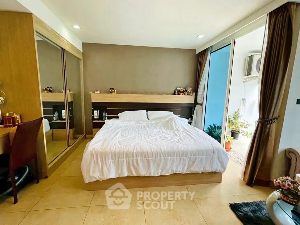 Modern bedroom with large bed, mirrored closet, and balcony access