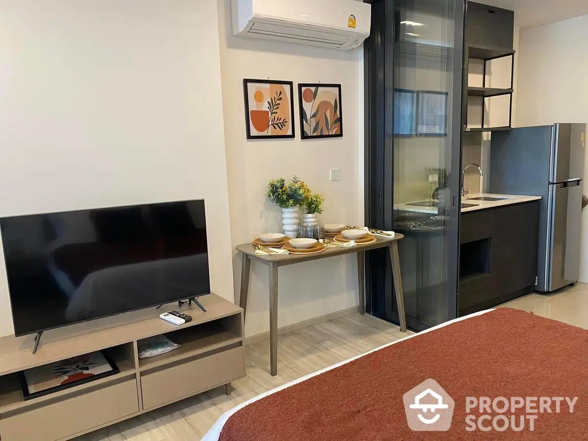 Modern studio apartment with integrated living space, featuring sleek kitchen appliances, cozy dining area, and a comfortable entertainment zone.