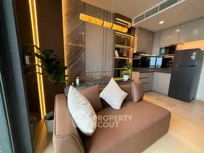 Modern open-layout kitchen and living area with stylish decor and lighting.