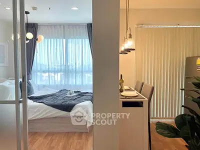 Modern apartment with cozy bedroom and stylish dining area, featuring elegant lighting and natural light.
