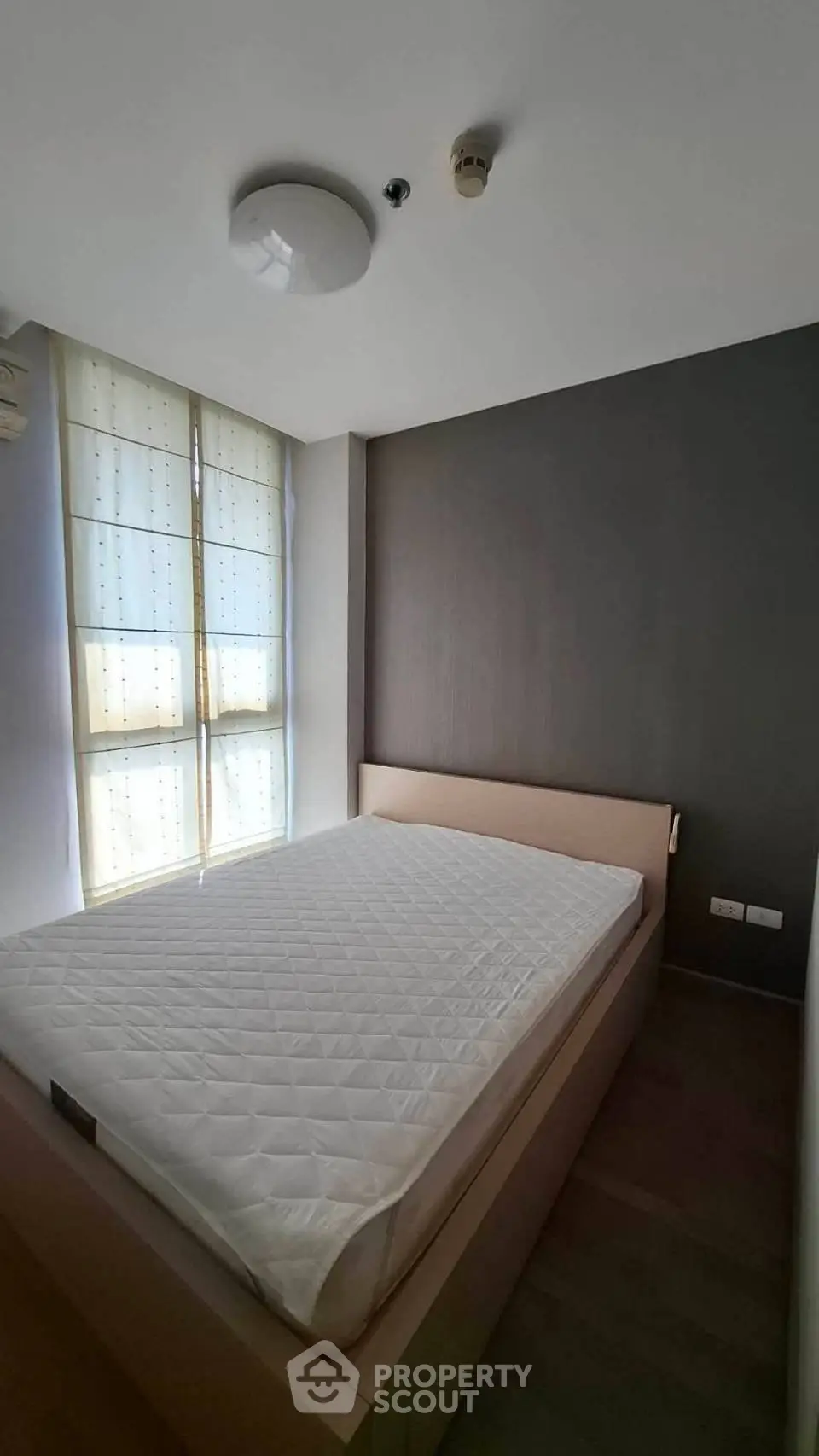 Modern bedroom with large window and minimalist design, featuring a comfortable bed and ample natural light.