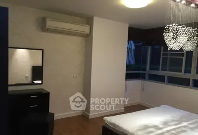 Modern bedroom with elegant chandelier and air conditioning, featuring a stylish vanity and large window.