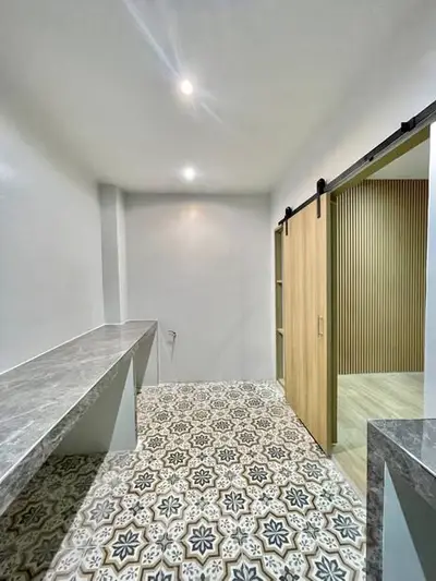 Stylish modern storage room with patterned tile flooring and sliding wooden door