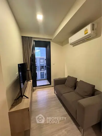 Cozy living room with modern sofa and balcony view, perfect for relaxation.