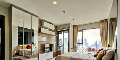 Modern bedroom with large windows offering a panoramic city view, mirrored wardrobe, and cozy furnishings, perfect for urban living.