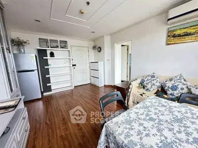 Charming living room with modern decor and wooden flooring, featuring cozy seating and stylish shelving.