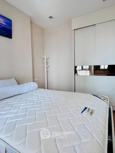 Spacious bedroom with modern decor and ample natural light, featuring a comfortable bed and sleek wardrobe.