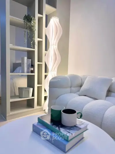 Stylish modern living room with cozy sofa, elegant lamp, and chic decor for a sophisticated ambiance.