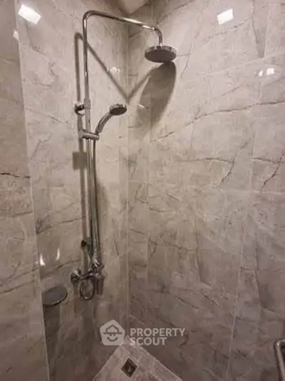 Modern bathroom shower with elegant marble tiles and dual showerheads.