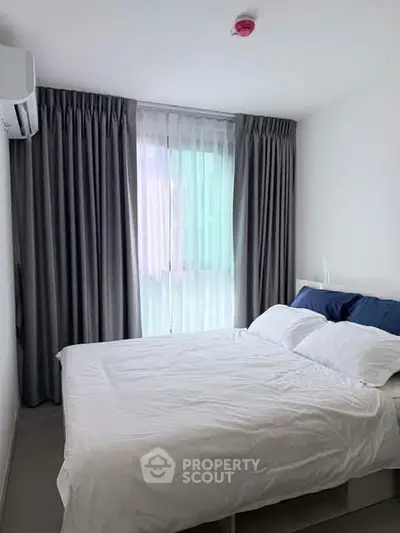Modern bedroom with large window and elegant curtains in a stylish apartment.