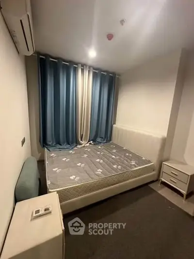 Cozy bedroom with modern furnishings and blue curtains, perfect for restful nights.