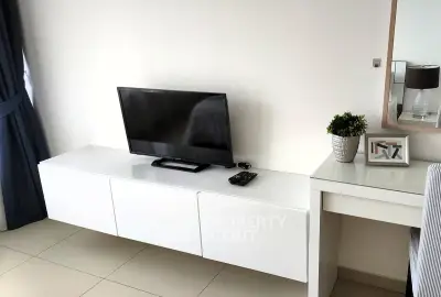 Modern living room with sleek white furniture and flat-screen TV, perfect for contemporary living.