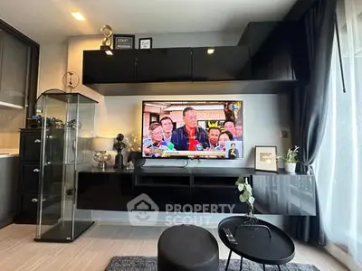 Modern living room with sleek black furniture and wall-mounted TV