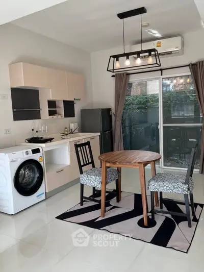 Modern kitchen with washing machine, dining table, and balcony view.