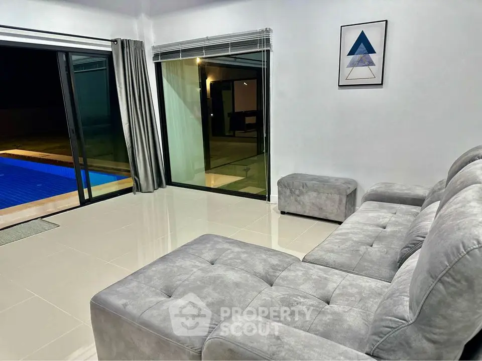 Modern living room with pool view and stylish gray sofa