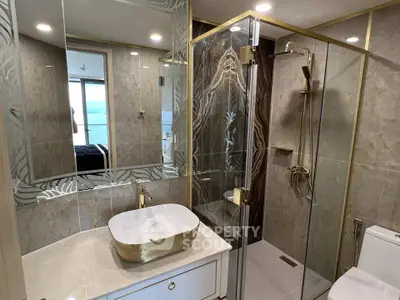 Luxurious modern bathroom with elegant gold fixtures and spacious glass shower